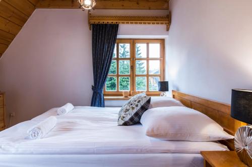 two beds in a room with a window at udanypobyt Dom Z Ogrodem in Zakopane