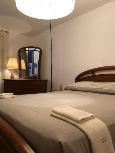een slaapkamer met een bed met een spiegel en een lamp bij Casa Gramapa in Rocca Priora