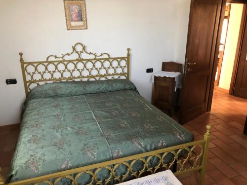 a bedroom with a bed with a green comforter at B&B Da Cleto in Gemmano