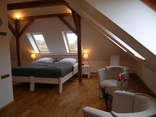 a attic bedroom with two beds and a chair at Haus Vincent Stralsund in Stralsund