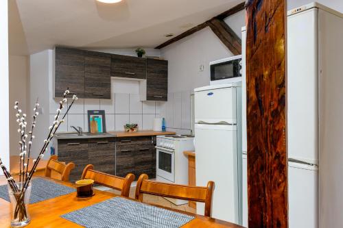 斯塞新的住宿－Strych Kościuszki - duży，厨房配有桌子和白色冰箱。