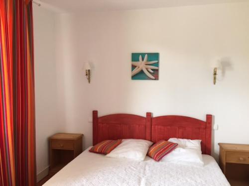 - une chambre avec un lit en bois et 2 oreillers dans l'établissement Villa Etche Xuria, à Biscarrosse-Plage