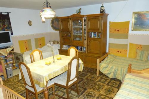 a living room with a table and a bedroom at Görbe Vendégház magyar klasszika in Tarcal