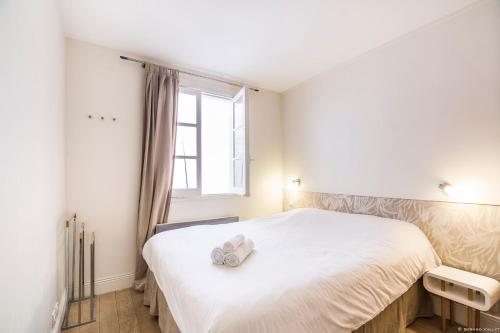 une chambre avec un grand lit blanc avec une fenêtre dans l'établissement alsace, à Bordeaux