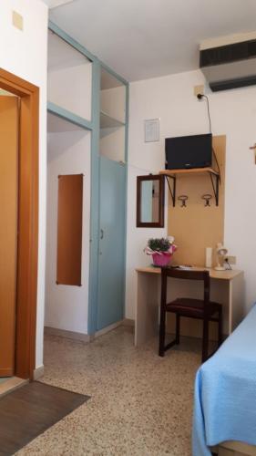 a bedroom with a bed and a desk with a television at Hotel Villa Dina in Lido di Jesolo