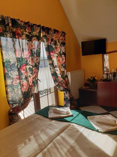 a bedroom with a bed with a window with a curtain at Malinowy Dwór in Ruda Śląska