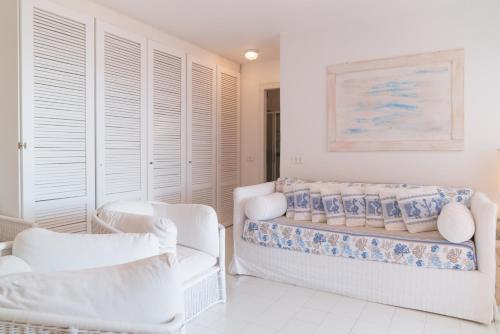 Camera bianca con 2 sedie e 1 letto di Portisco a Porto Rotondo