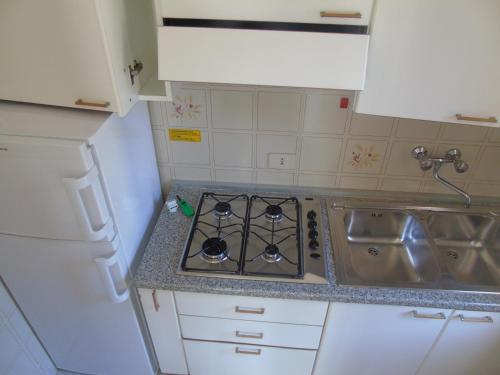a kitchen with a stove and a sink at Villa Valeria in Lignano Sabbiadoro