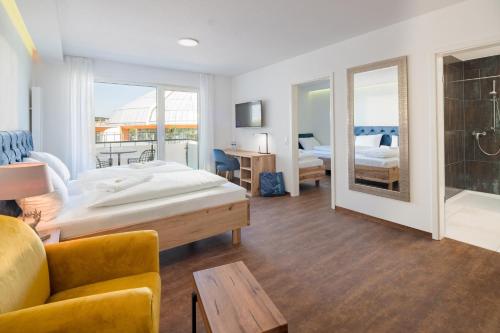 a bedroom with a bed and a living room with a couch at Thermalhotel Aulendorf in Aulendorf