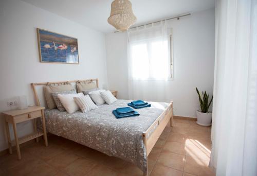 Un dormitorio con una cama con toallas azules. en Mar y tierra en Conil de la Frontera