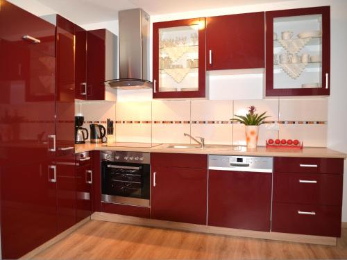 a kitchen with red cabinets and a sink at Haus Senel in Eben im Pongau