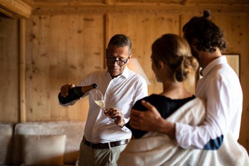 Ein Mann schenkte einer Frau ein Glas Wein ein in der Unterkunft Hotel Patrizia in Dorf Tirol