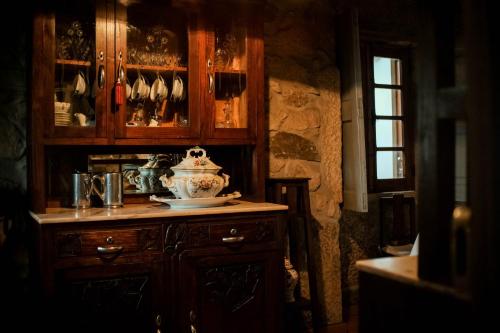 um armário de madeira com um vaso em cima de uma mesa em The Bakery Guesthouse em Fundão