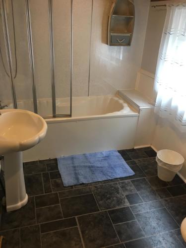 een badkamer met een bad, een wastafel en een toilet bij Isambard Cottage in Weymouth