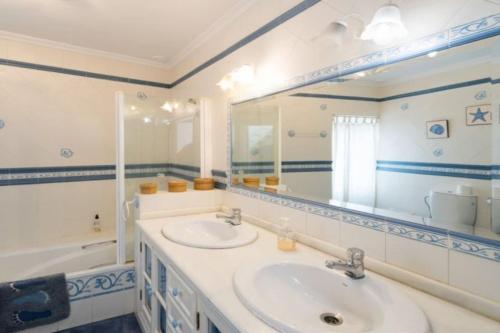 y baño con lavabo, espejo y bañera. en Casa GaLuz, entre la Sierra y el Mar, en Alcalá de los Gazules