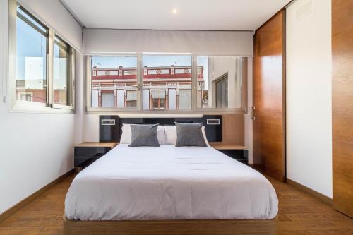 a bedroom with a large white bed with two pillows at VLVilla - Villa de lujo en Valencia con piscina privada y sala de cine in Burjasot