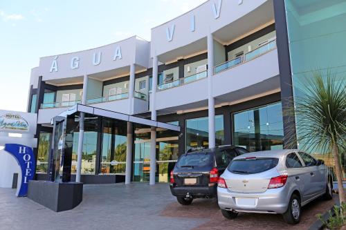 two cars parked in front of a building at Água Viva Hotel in Olímpia