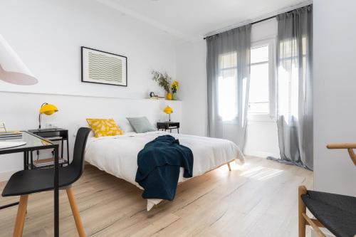 a white bedroom with a bed and a desk at Casa Cosi - Eixample 3 in Barcelona