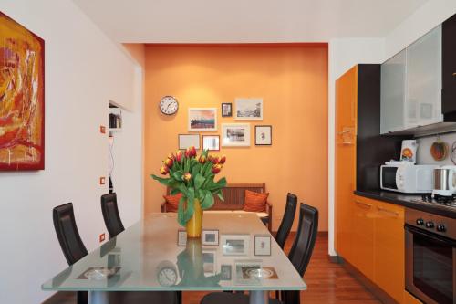 une salle à manger avec une table et un vase de fleurs dans l'établissement PadovaResidence Apartments - tra Piazza delle Erbe e il Duomo, à Padoue
