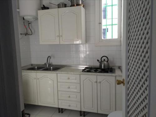 una cocina con armarios blancos y fregadero en Casa Maldonado, en Arcos de la Frontera