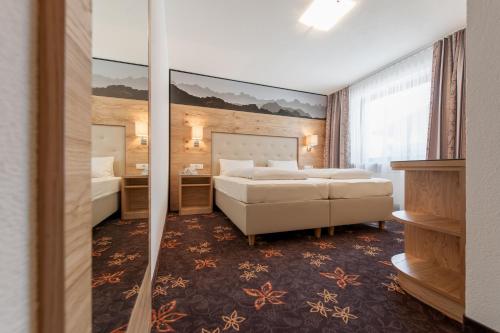 a hotel room with two beds and a mirror at Heiners in Sölden