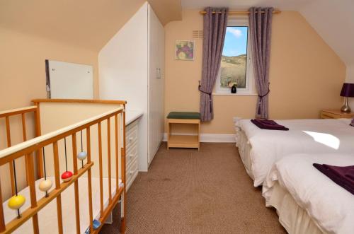 a bedroom with two beds and a staircase at Cottage 139 - Clifden in Clifden