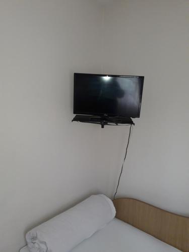 フォクシャニにあるPensiunea SENA Focsaniの白壁の薄型テレビ