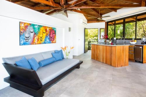 a living room with a couch and a kitchen at Tulemar in Manuel Antonio