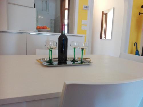 シルミオーネにあるCasa Vacanza Clavelのカウンターにワイン1本とグラス2杯