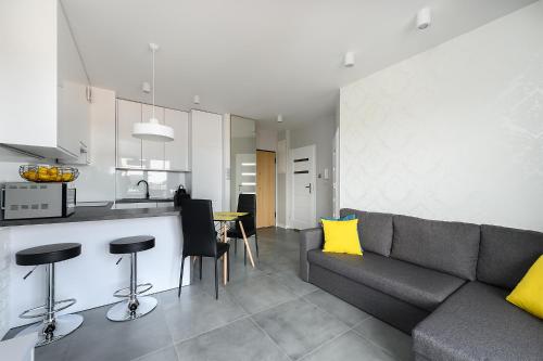 a living room with a couch and a kitchen at Expo Home Apartment by PinPoint in Łódź