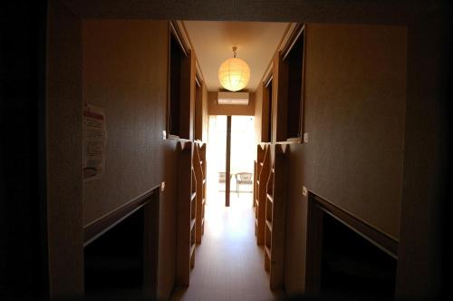 a hallway with a light fixture and a hallway with a hallway sidx sidx at Chambre dhote Tatami in Suwa