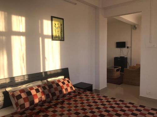 1 dormitorio con 1 cama y suelo a cuadros en Lashisha en Shillong