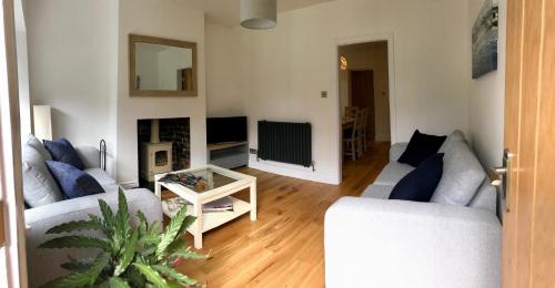 a living room with two couches and a tv at Eden Cottage in Frodsham