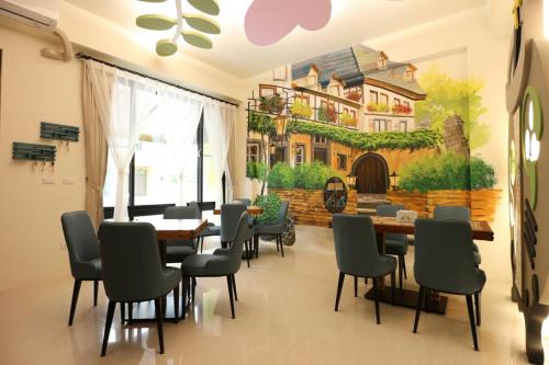 a dining room with a painting of a house at Fall in love with Madai in Taitung City