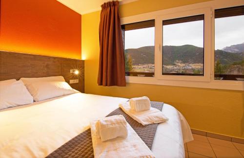 a bedroom with a bed with two towels on it at Apartaments Giberga in LʼAldosa