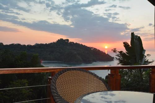 a chair on a balcony with a view of the ocean at Tulemar in Manuel Antonio