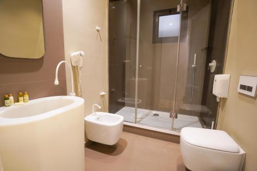 a bathroom with a tub and a toilet and a shower at Le Stanze di Piazza Cairoli in Messina