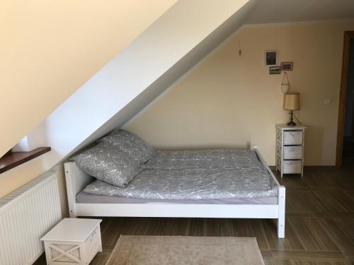 a bed in a room under the stairs at Przytulisko na Mazurach in Ruciane-Nida