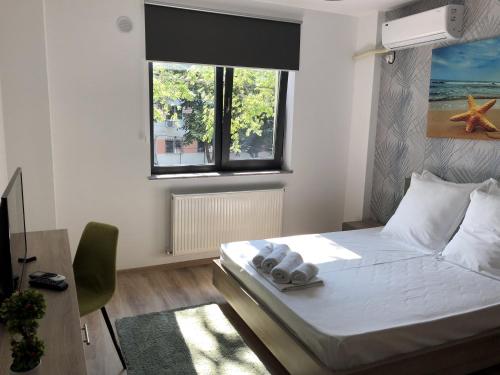 een kleine slaapkamer met een bed en een raam bij Lira Holiday Apartments in Eforie Nord