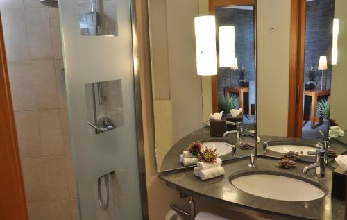 a bathroom with two sinks and a large mirror at Hotel Eggers Hamburg in Hamburg