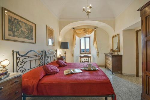 1 dormitorio con 1 cama grande con manta roja en Medieval Palazzo Becci, en San Gimignano