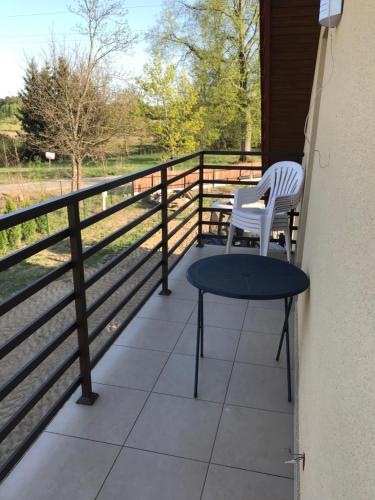 a balcony with two chairs and a table and a fence at Przytulisko na Mazurach in Ruciane-Nida