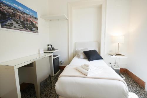 a white room with a desk and a bed at Le Stanze di Piazza Cairoli in Messina