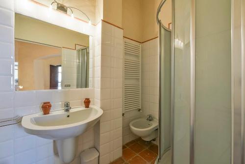 y baño con lavabo, aseo y espejo. en Medieval Palazzo Becci, en San Gimignano