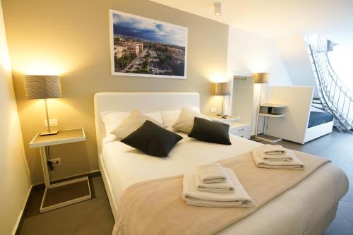a bedroom with a white bed with towels on it at Le Stanze di Piazza Cairoli in Messina