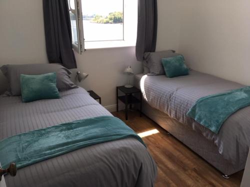 a bedroom with two beds and a window at Cottage at Youghal Bridge in DʼLoughtane Cross Roads