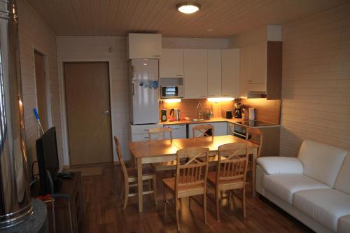 a kitchen and dining room with a table and a couch at Findomik Cottages in Hankasalmi