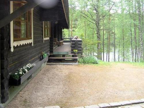 a porch of a house in the woods at Holiday Home Sokeelampi by Interhome in Matku