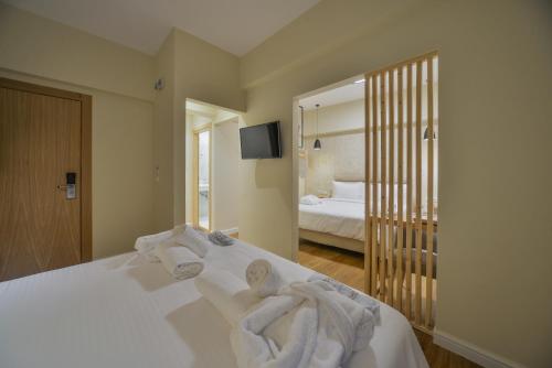 a bedroom with a bed with towels on it at A.P. Acropolis View Apartments in Athens