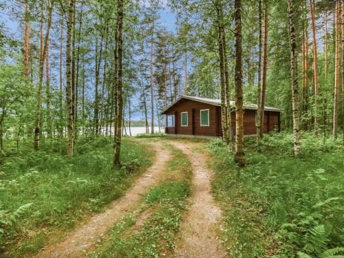 a dirt road leading to a cabin in the woods at Holiday Home Mäntyranta by Interhome in Harjula